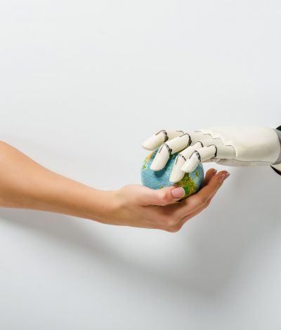 cropped image of woman with hand prosthesis holding earth model through holes on white cropped image of woman with hand prosthesis holding earth model through holes on white